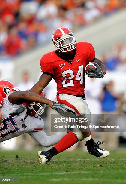 Running Back Knowshon Moreno of the Georgia Bulldogs rushes as linebacker Brandon Spikes the Florida Gators defends at Jacksonville Municipal Stadium...