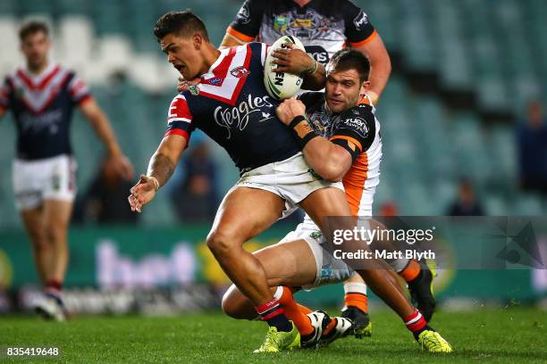 Latrell Mitchell of the Roosters is tackled during the round 24 NRL match between the Sydney Roosters and the Wests Tigers at Allianz Stadium on...