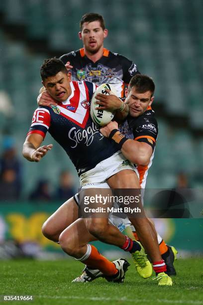 Latrell Mitchell of the Roosters is tackled during the round 24 NRL match between the Sydney Roosters and the Wests Tigers at Allianz Stadium on...