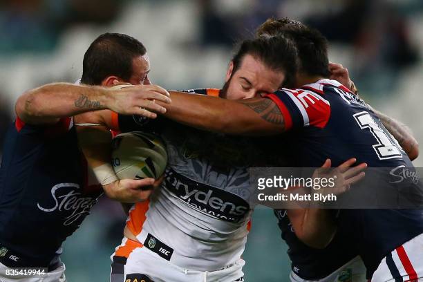 Aaron Woods of the Tigers is tackled during the round 24 NRL match between the Sydney Roosters and the Wests Tigers at Allianz Stadium on August 19,...