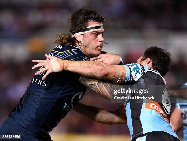 Ethan Lowe of the Cowboys is tackled by James Maloney of the Sharks during the round 24 NRL match between the North Queensland Cowboys and the...