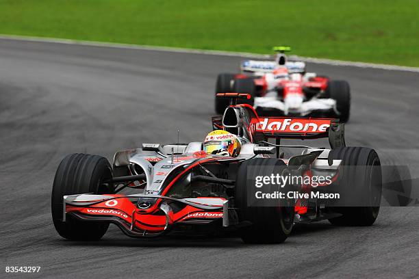 Lewis Hamilton of Great Britain and McLaren Mercedes leads from Timo Glock of Germany and Toyota on his way to winning the Formula One World...