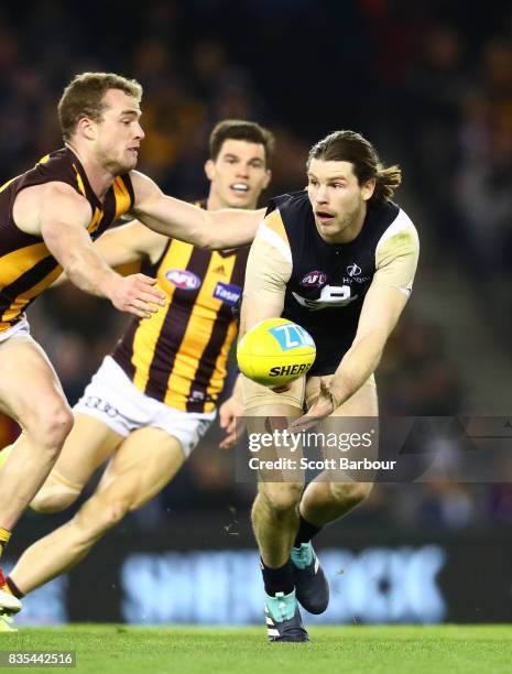 Bryce Gibbs of the Blues is tackled by Tom Mitchell of the Hawks during the round 22 AFL match between the Carlton Blues and the Hawthorn Hawks at...