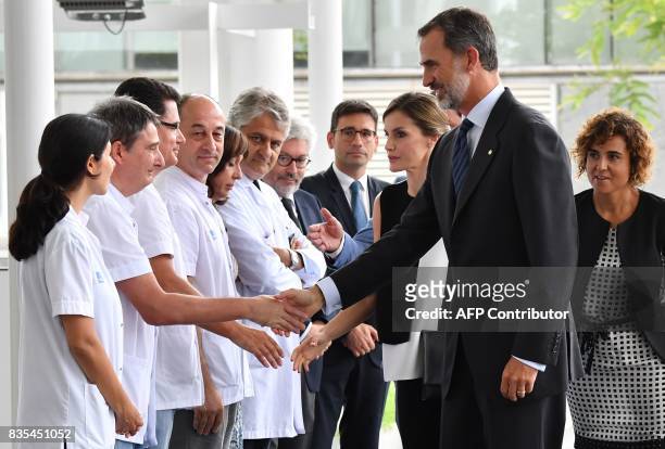 Spain's King Felipe VI and Queen Letizia shake hands with medical staff of the Hospital del Mar in Barcelona, as they arrive to visit victims of the...