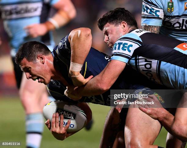 Shane Wright of the Cowboys is tackled by Chad Townsend of the Sharks during the round 24 NRL match between the North Queensland Cowboys and the...