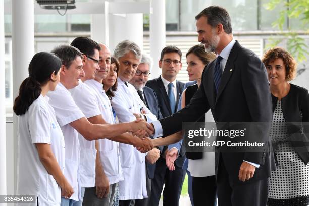 Spain's King Felipe VI and Queen Letizia shake hands with medical staff of the Hospital del Mar in Barcelona, as they arrive to visit victims of the...