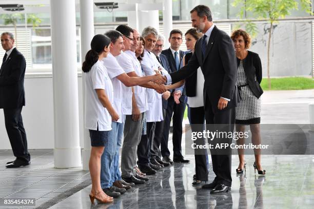 Spain's King Felipe VI and Queen Letizia shake hands with medical staff of the Hospital del Mar in Barcelona, as they arrive to visit victims of the...