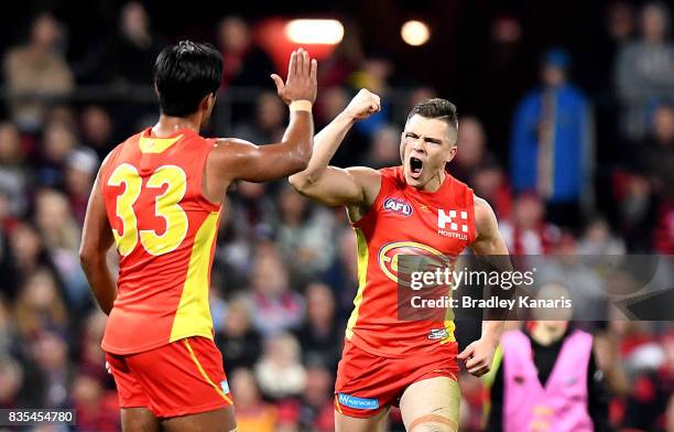 Ben Ainsworth of the Suns celebrates after kicking a goal during the round 22 AFL match between the Gold Coast Suns and the Essendon Bombers at...