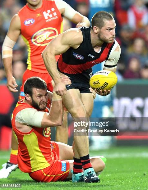 David Zaharakis of the Bombers is pressured by the defence during the round 22 AFL match between the Gold Coast Suns and the Essendon Bombers at...