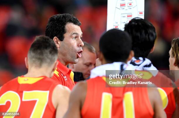 Coach Dean Solomon of the Suns talks to his players at the 3rd quarter time break during the round 22 AFL match between the Gold Coast Suns and the...