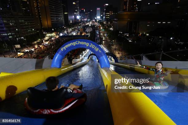 South Koreans slide down on an inflatable ring during the 'Bobsleigh In the City' on August 19, 2017 in Seoul, South Korea. The 22-metre-high...