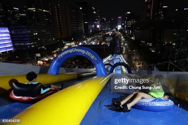 South Korean girls slide down on an inflatable ring during the 'Bobsleigh In the City' on August 19, 2017 in Seoul, South Korea. The 22-metre-high...