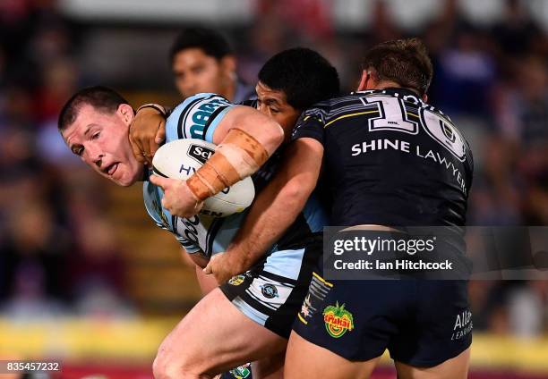 Paul Gallen of the Sharks is tackled by Scott Bolton and John Asiata of the Cowboys during the round 24 NRL match between the North Queensland...