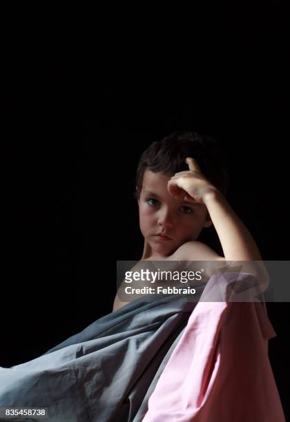 portrait of boy covered with gray and pink cloths - chiaroscuro - fotografias e filmes do acervo