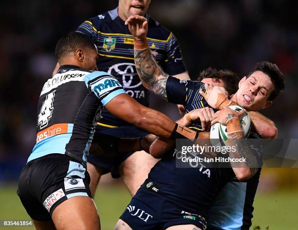 Benjamin Hampton of the Cowboys is tackled by Ricky Leutele of the Sharks during the round 24 NRL match between the North Queensland Cowboys and the...