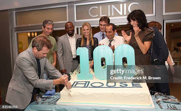 Actor Hugh Laurie actress Lisa Edelstein and the cast of "House" cut the cake during the shows 100th episode celebration on the set at Fox on...