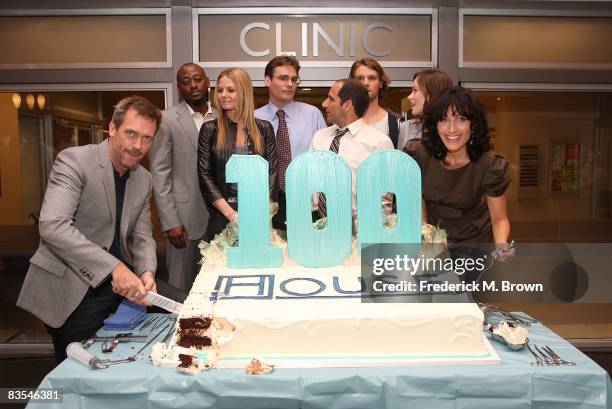 Actor Hugh Laurie actress Lisa Edelstein and the cast of "House" cut the cake during the shows 100th episode celebration on the set at Fox on...
