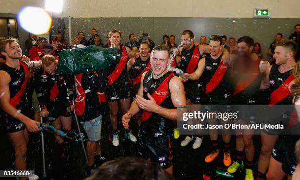 Joshua Begley of the Bombers celebrates with team mates after victory during the round 22 AFL match between the Gold Coast Suns and the Essendon...