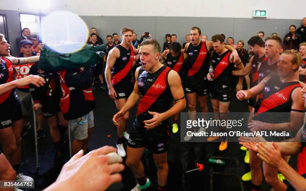 Joshua Begley of the Bombers celebrates with team mates after victory during the round 22 AFL match between the Gold Coast Suns and the Essendon...