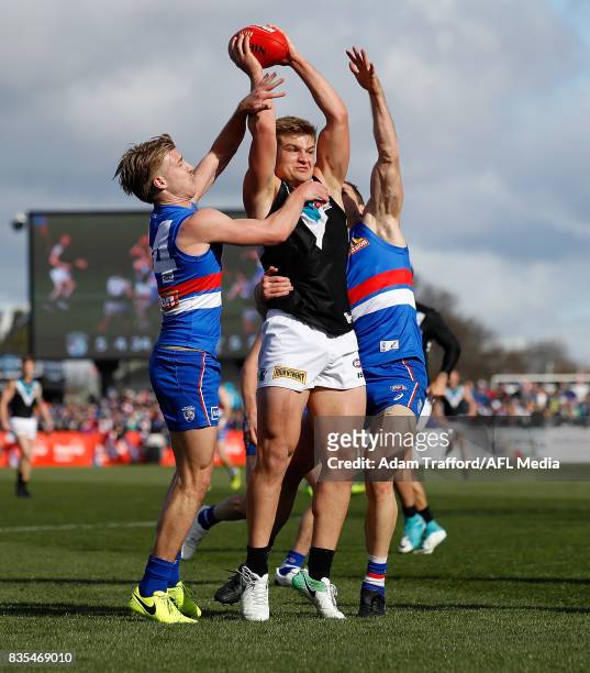 Ollie Wines of the Power is tackled by Shane Biggs and Dale Morris of the Bulldogs during the 2017 AFL round 22 match between the Western Bulldogs...