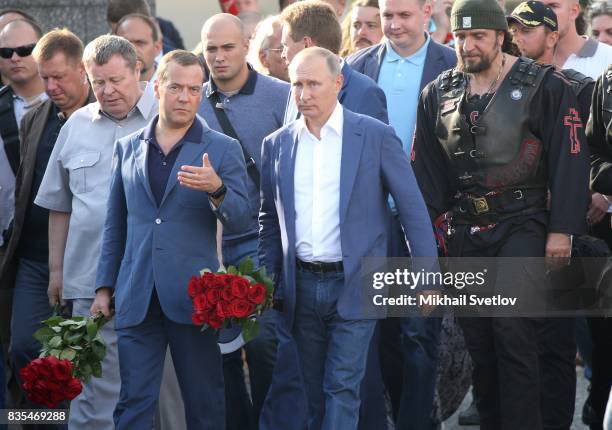 Russian President Vladimir Putin litsnens to Prime Minister Dmitry Mevedev as Night Wolves Bikers Club President Alexander Zaldostanov, also known as...