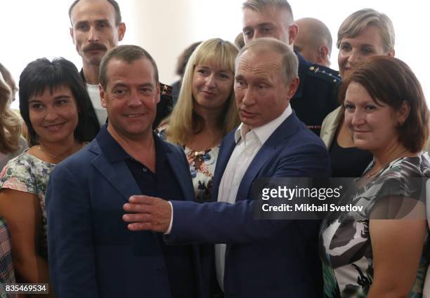 Russian President Vladimir Putin and Prime Minister Dmitry Mevedev pose for a group photo while visiting a newly opened school on August 18, 2017 on...