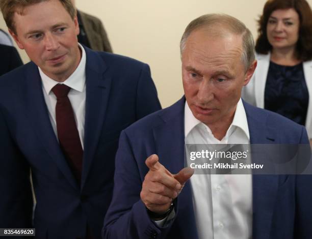 Russian President Vladimir Putin talks to Governor of Sevastopol Dmitry Ovsyannikov while visiting a newly opened school on August 18, 2017 on...