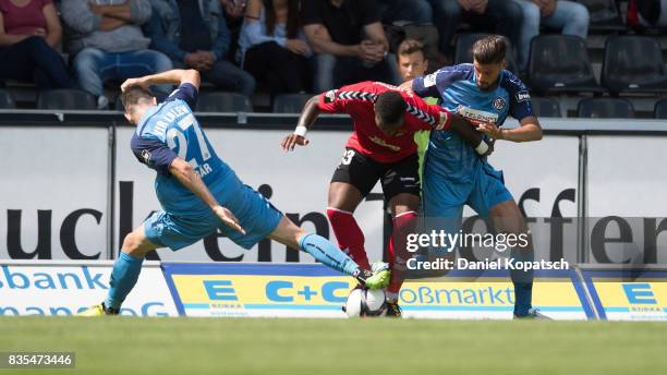 Joseph-Claude Gyau of Grossaspach is challenged by Marcel Baer of Aalen and Torben Rehfeldt of Aalen during the 3. Liga match between SG Sonnenhof...