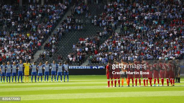 Players and match officials observe a minute's silence in memory of the victims of Thursday's terrorist attacks in Spain during the Bundesliga match...