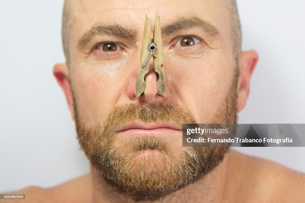 Portrait of man with clothespin on his nose