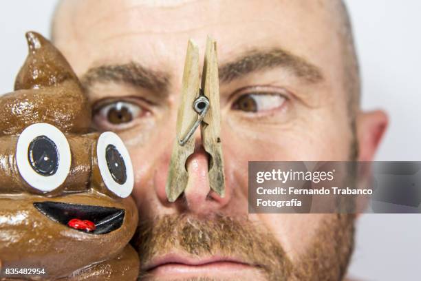 man with his nose covered to not smell the poop - clothes peg stock pictures, royalty-free photos & images