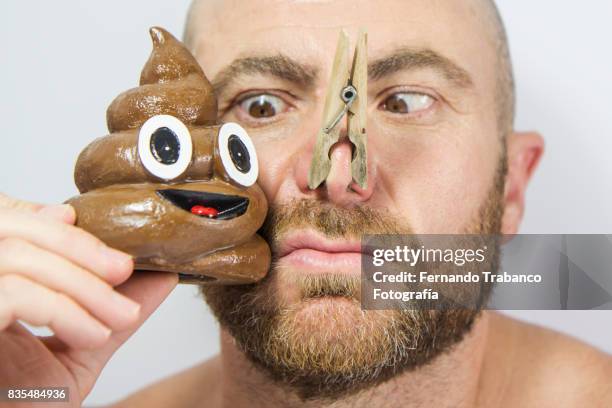 man with his nose covered to not smell the poop - gastroenteritis stock pictures, royalty-free photos & images