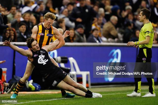 James Sicily of the Hawks wrestles Jed Lamb of the Blues to the ground behind play during the round 22 AFL match between the Carlton Blues and the...