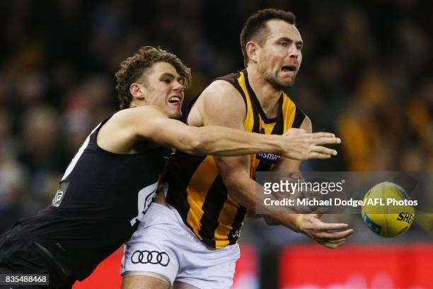 Luke Hodge of the Hawks is caught by Charlie Curnow of the Blues during the round 22 AFL match between the Carlton Blues and the Hawthorn Hawks at...