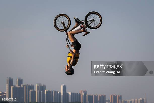 An extreme cycling enthusiast performs a stunt with a bicycle before falling into the East Lake on August 19, 2017 in Wuhan, Hubei province, China....