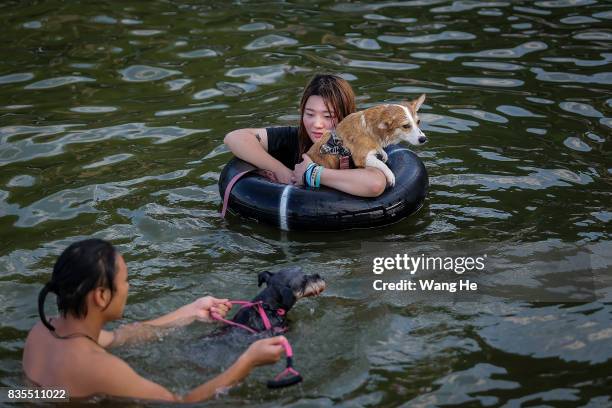 Residents hold dogs in East Lake on August 19, 2017 in Wuhan, Hubei province, China. This activity, which requires participants to ride their bikes...