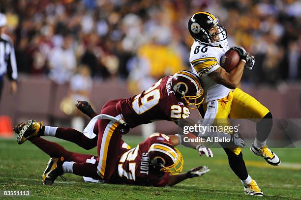 Hines Ward of the Pittsburgh Steelers runs after a catch as Leigh Torrence and Fred Smoot of the Washington Redskins make the tackle during their...