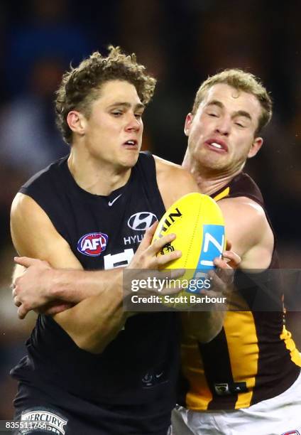 Charlie Curnow of the Blues is tackled by Tom Mitchell of the Hawks during the round 22 AFL match between the Carlton Blues and the Hawthorn Hawks at...