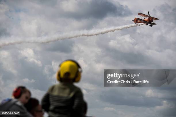 The Brietling Wingwalkers fly past children wearing ear defenders during a flying display at the Biggin Hill Festival of Flight on August 19, 2017 in...