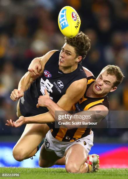 Charlie Curnow of the Blues is tackled by Tom Mitchell of the Hawks during the round 22 AFL match between the Carlton Blues and the Hawthorn Hawks at...