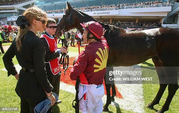 Jockey Damien Oliver speaks to Francesca Cumani after the favourite Mad Rush finished unplaced in the Melbourne Cup in Melbourne on November 4, 2008....