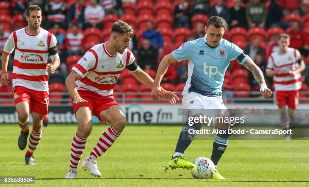 Blackpool's Callum Cooke gets away from Doncaster Rovers' Ben Whiteman during the Sky Bet League One match between Doncaster Rovers and Blackpool at...