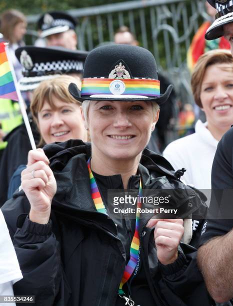 Police officer waves a rainbow flag during the Glasgow Pride march on August 19, 2017 in Glasgow, Scotland. The largest festival of LGBTI celebration...