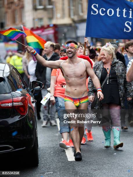 Participant wears rainbow pants and waves a flag during the Glasgow Pride march on August 19, 2017 in Glasgow, Scotland. The largest festival of...