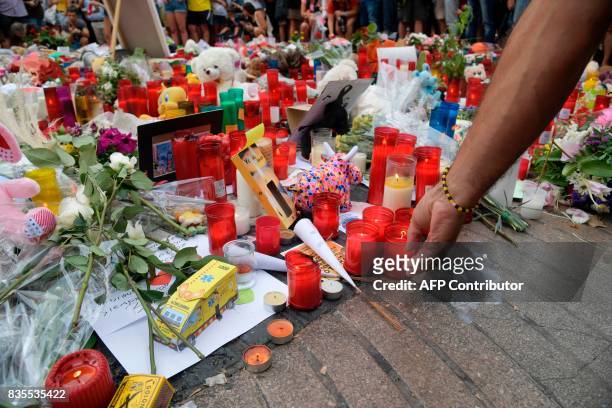 People pay tribute to the victims of the Barcelona attack on Las Ramblas boulevard in Barcelona on August 19 two days after a van ploughed into the...