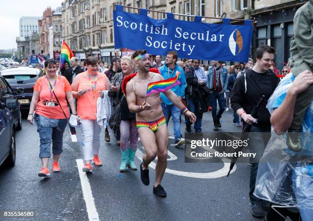 Participant wears rainbow pants and waves a flag during the Glasgow Pride march on August 19, 2017 in Glasgow, Scotland. The largest festival of...