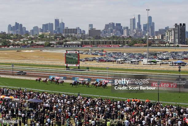 Horses race past the large crowd with the Melbourne skyline in the background during The Melbourne Cup Carnival meeting at Flemington Racecourse on...