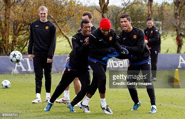 Nani , Anderson and Cristiano Ronaldo of Manchester United joke together during a training session held at their Carrington Training Complex on...
