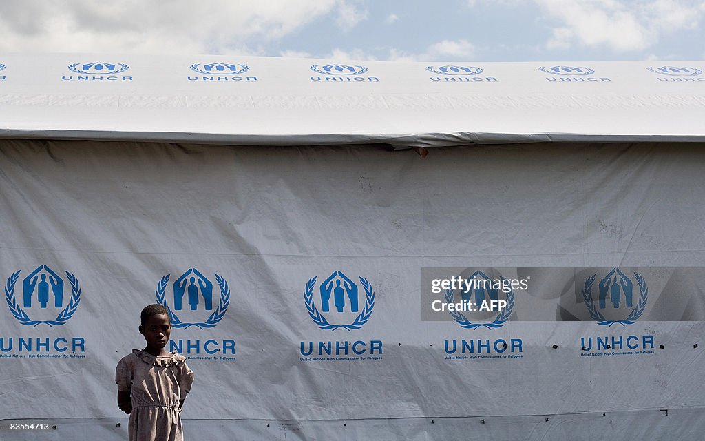 A girl stands in front of a tent with th