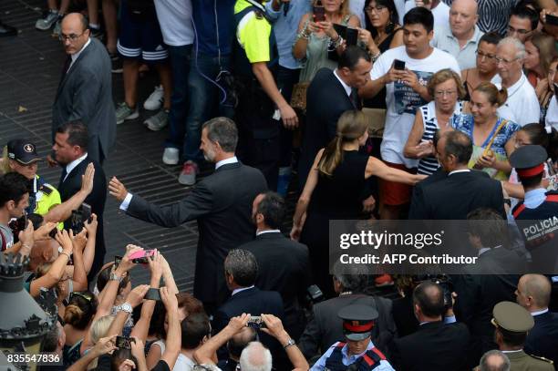 Spain's King Felipe VI and Spain's Queen Letizia greet people as they leave after paying tribute to the victims of the Barcelona attack on Las...